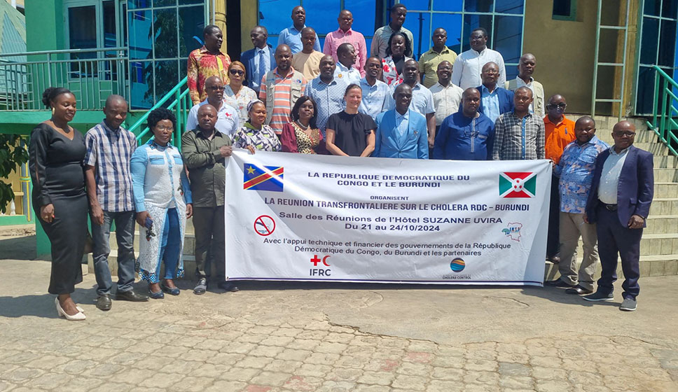 A group of participants with a banner on the acroos-border meeting on cholera in Burundi